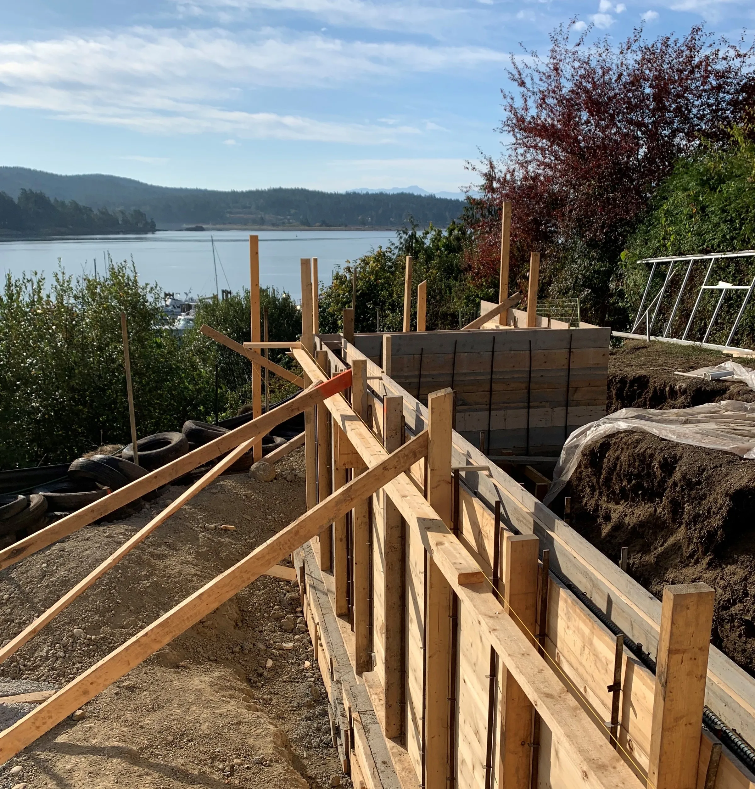 6825 West Coast Road, Sooke — waterfront new-build home under construction on a sloped oceanfront lot